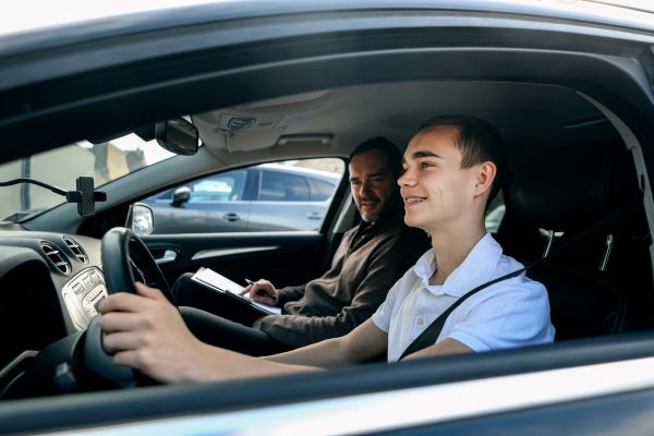 Male driving student and instructor in car