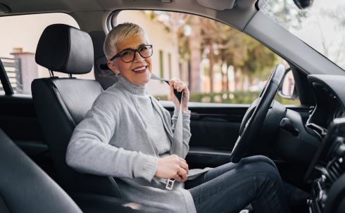 Senior driver buckling car seatbelt